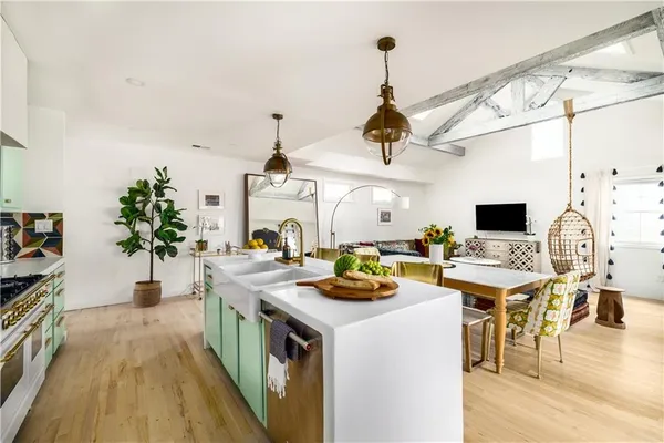 a kitchen with a stove a refrigerator and a dining table with wooden floor
