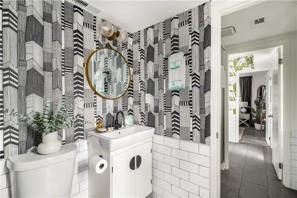 a bathroom with a sink and mirror with toilet