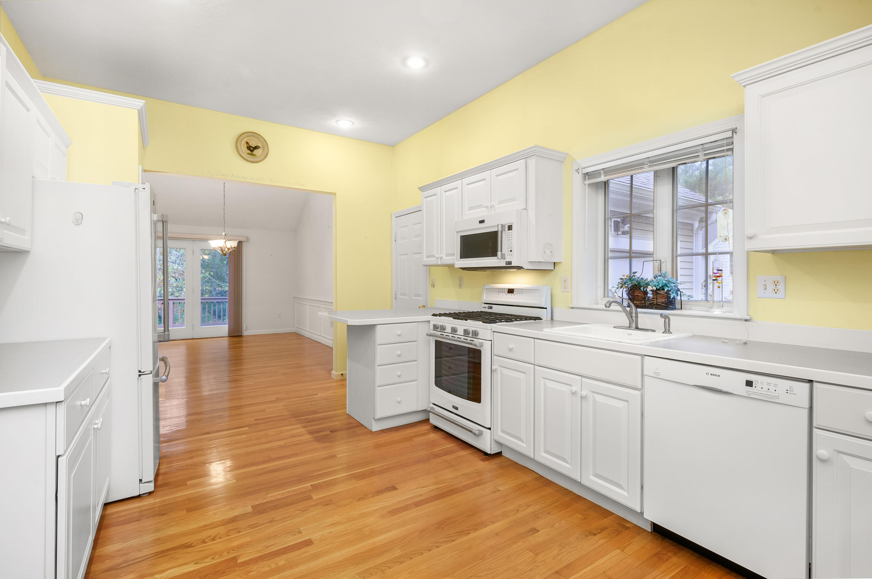 105 Snead Drive Mashpee, MA 02649 - Photo 12 of 35 a kitchen with stainless steel appliances granite countertop a stove and white cabinets with wooden floor