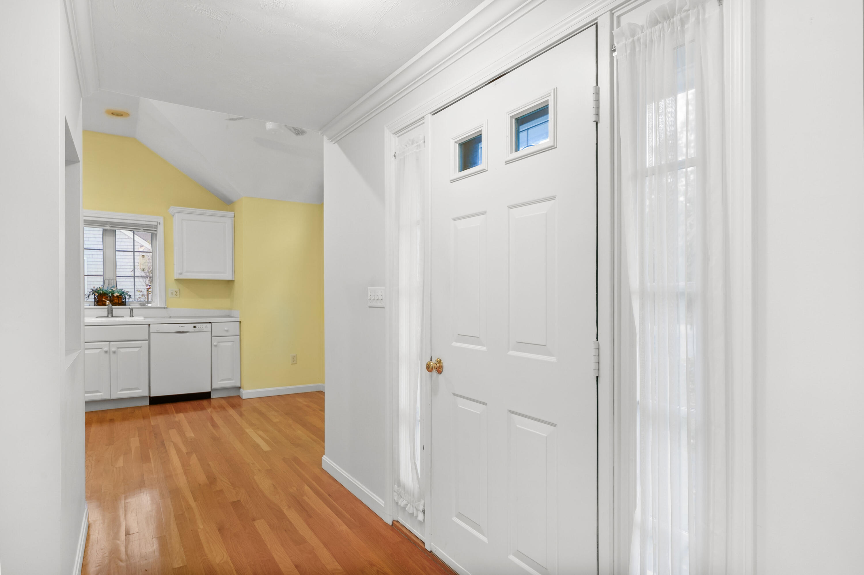 105 Snead Drive Mashpee, MA 02649 - Photo 10 of 35 a view of a kitchen with white cabinets and wooden floor