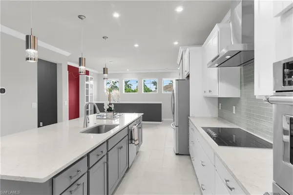 a kitchen with stainless steel appliances kitchen island a sink stove and cabinets