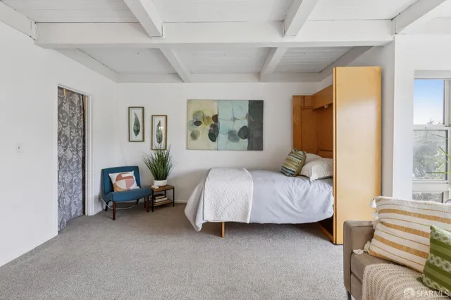 a spacious bedroom with a bed and chair in it