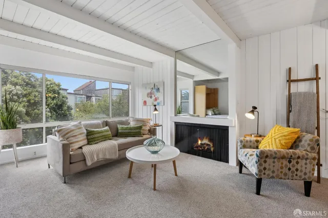 a spacious bedroom with a bed a couch and a large window