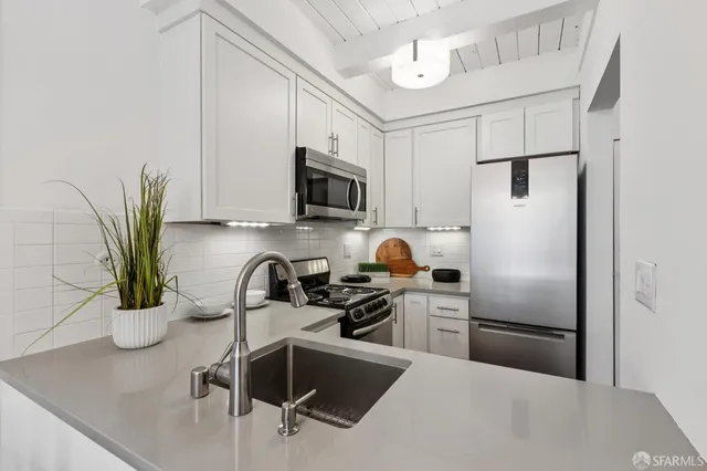 a kitchen with stainless steel appliances a stove a microwave and sink