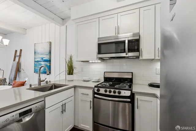a view of a kitchen with a sink and chandelier