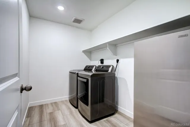 a kitchen with stainless steel appliances granite countertop a refrigerator a stove and a wooden floors