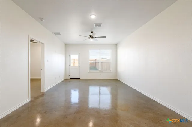 an empty room with windows and cabinet