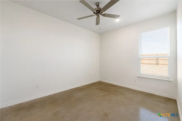 an empty room with a window and a fan