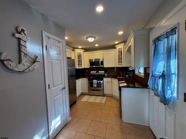 a kitchen with stainless steel appliances kitchen island granite countertop a refrigerator and a stove top oven