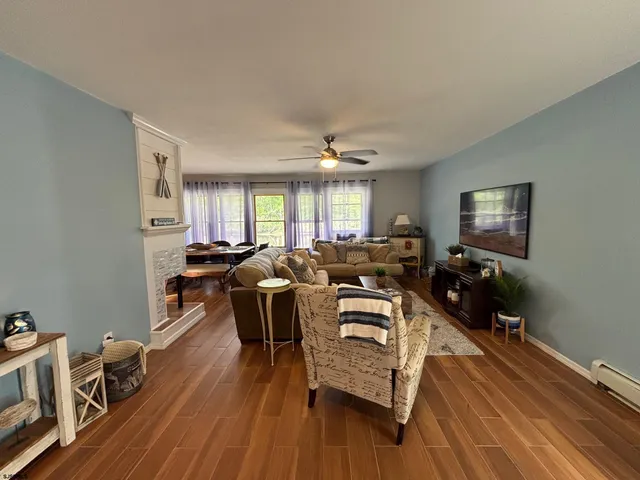 a living room with furniture a wooden floor and a window