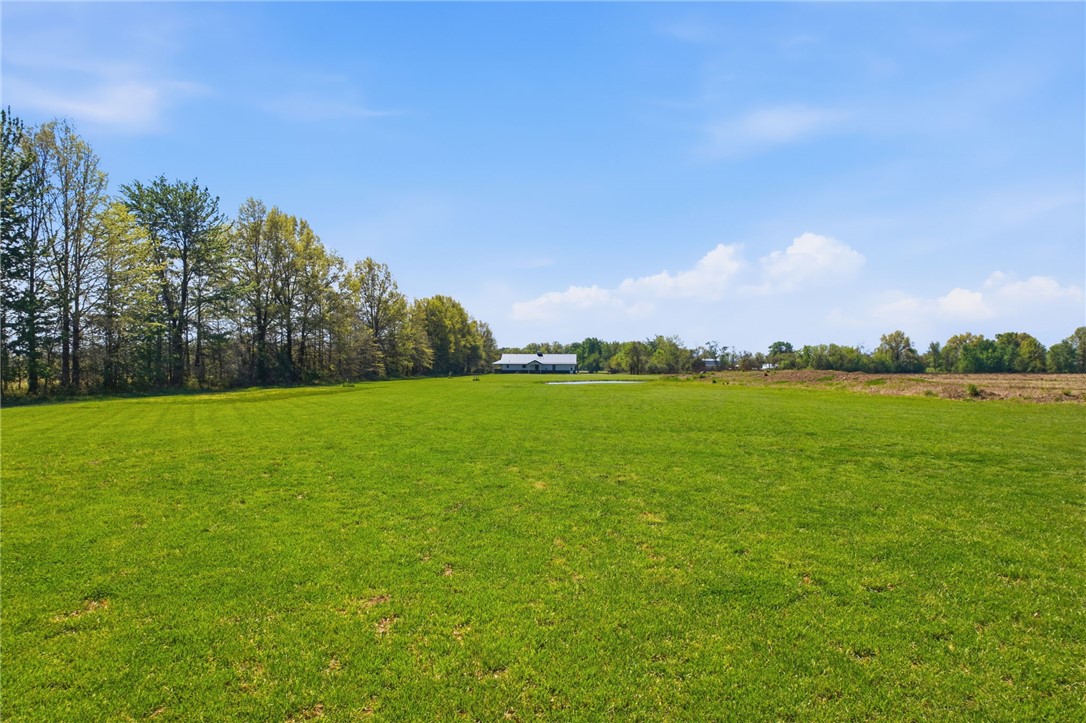 1602 Westboro Road Blanchester, OH 45107 - Photo 79 of 81 Expansive green acreage surrounds a distant, secluded home under a vibrant sky.