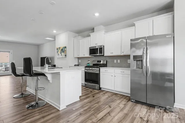 a kitchen with a refrigerator and a stove top oven