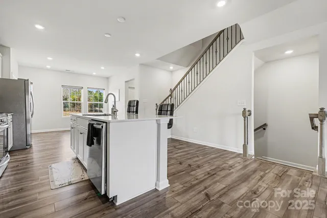 a view of a kitchen with furniture and wooden floor