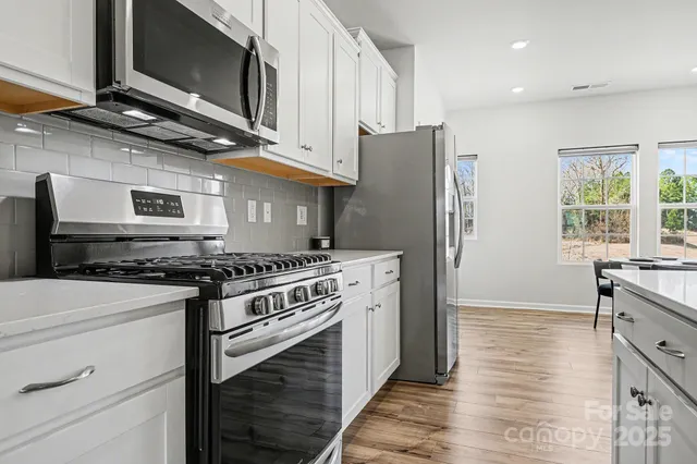 a kitchen with stainless steel appliances granite countertop a stove and a refrigerator