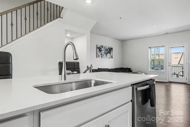 a view with a sink and dishwasher with wooden floor