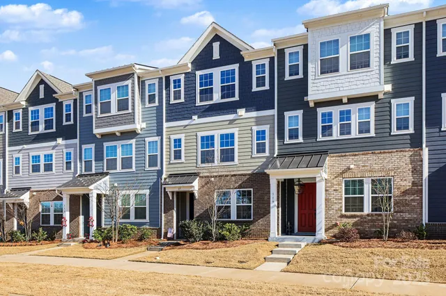 a front view of a brick building next to a yard