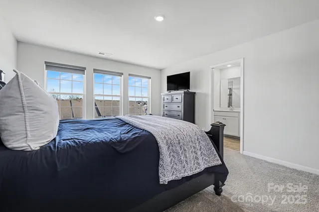 a bedroom with a large bed and a flat tv screen on dresser