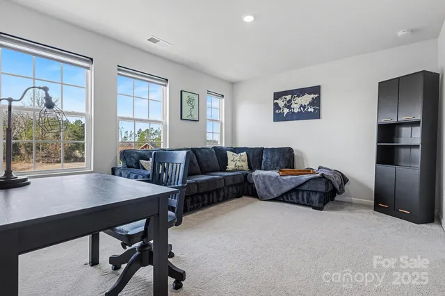a living room with furniture a large window and a wooden floor