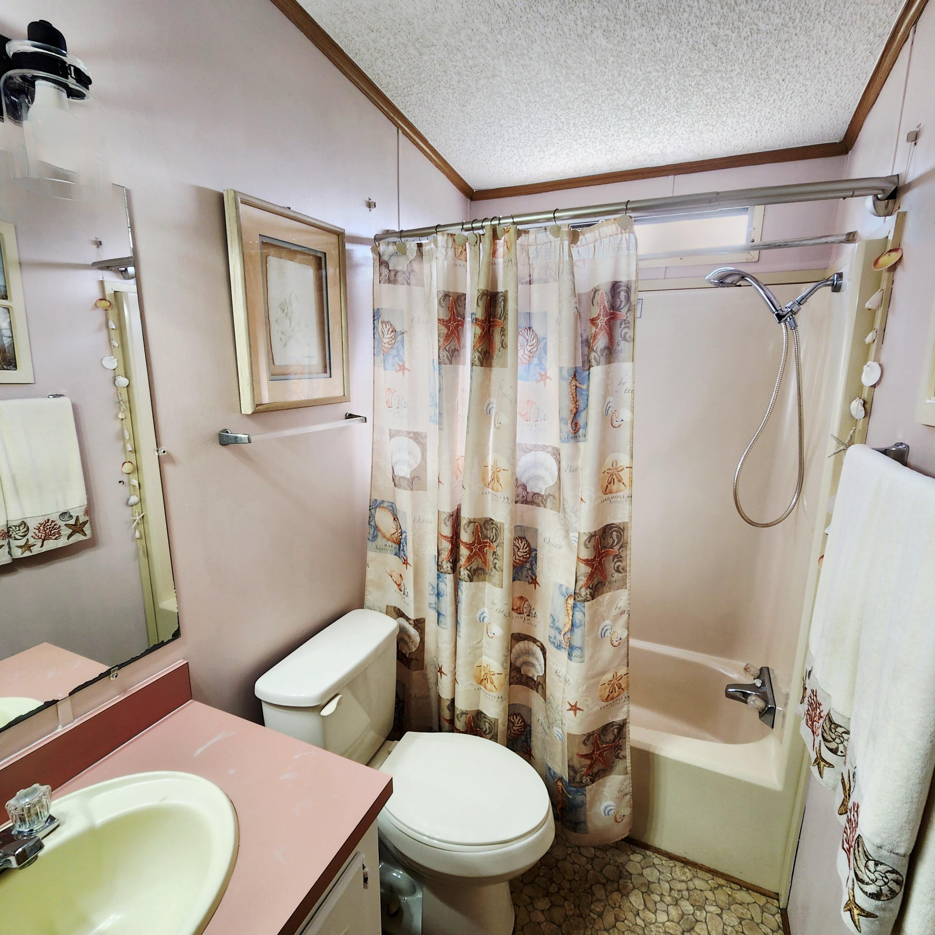 526 Hemingway Terrace, Unit F02 Fort Pierce, FL 34982 - Photo 25 of 55 a white toilet sitting next to a bathroom sink and a shower