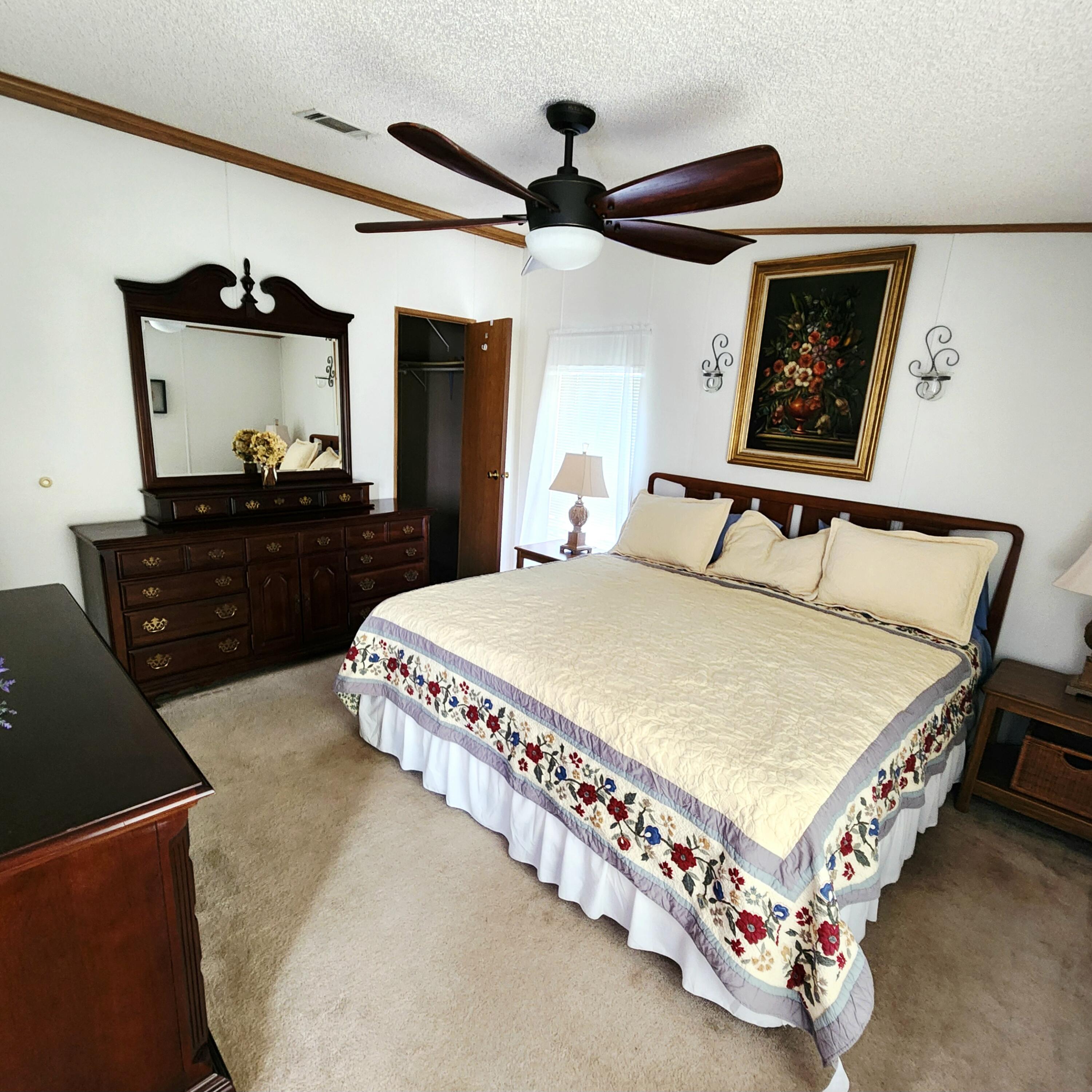 526 Hemingway Terrace, Unit F02 Fort Pierce, FL 34982 - Photo 27 of 55 a bedroom with a bed and dresser with mirror