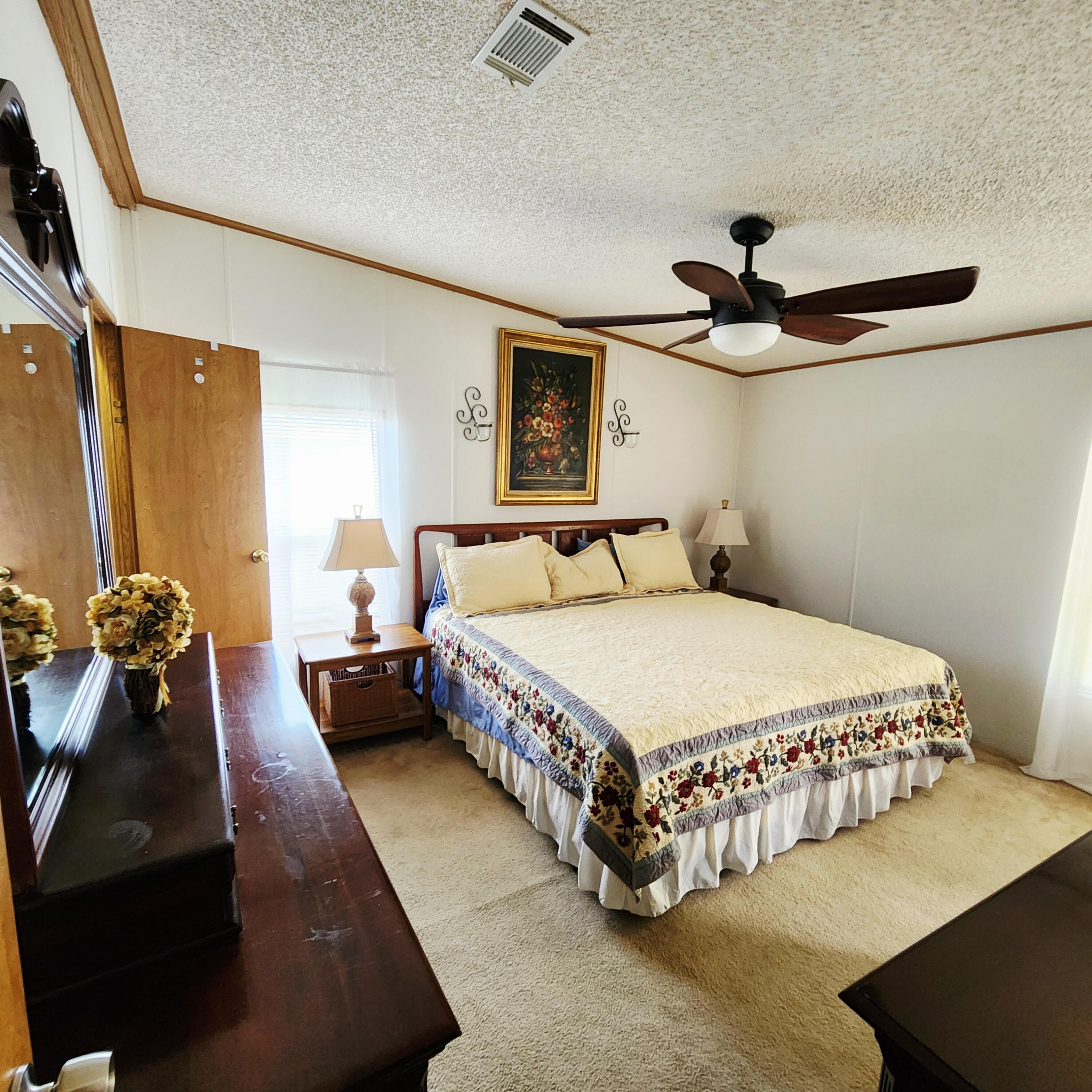 526 Hemingway Terrace, Unit F02 Fort Pierce, FL 34982 - Photo 28 of 55 a bedroom with a large bed and a chandelier