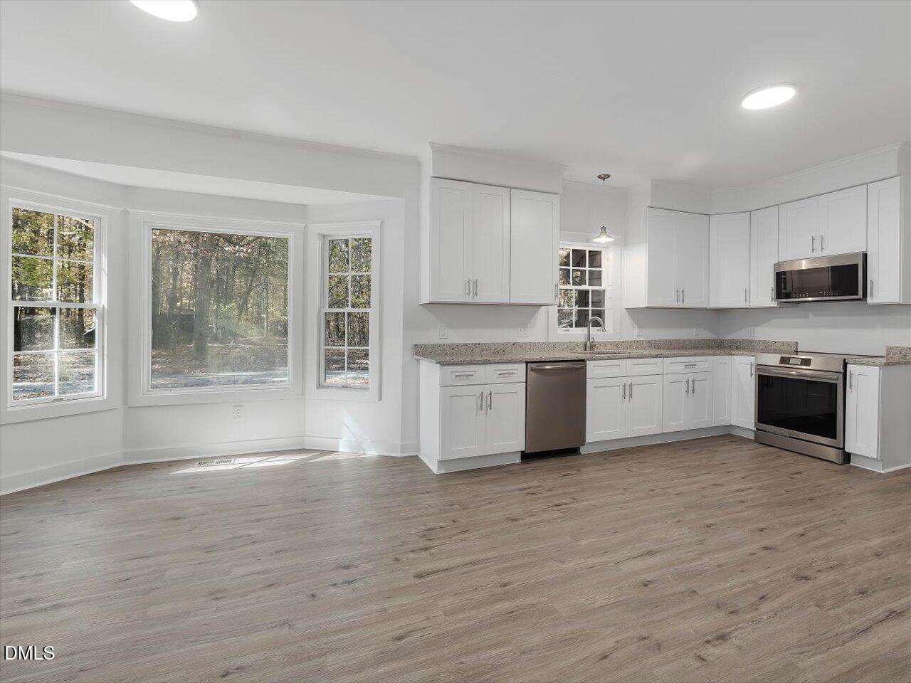 1838 Alex Cockman Road Pittsboro, NC 27312 - Photo 13 of 53 a large kitchen with cabinets wooden floor and a window