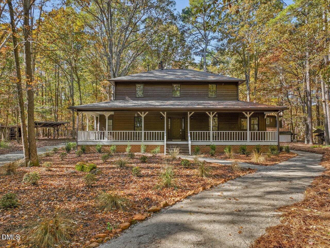 1838 Alex Cockman Road Pittsboro, NC 27312 - Photo 2 of 53 a front view of a house with a garden