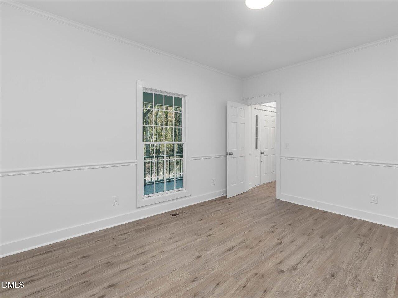 1838 Alex Cockman Road Pittsboro, NC 27312 - Photo 10 of 53 an empty room with wooden floor and windows