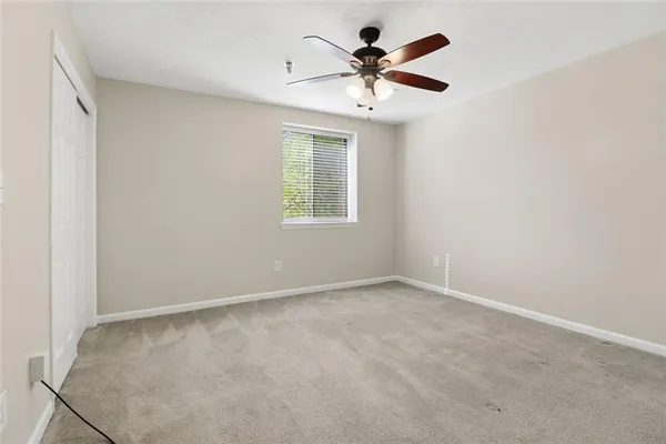an empty room with a window and a fan