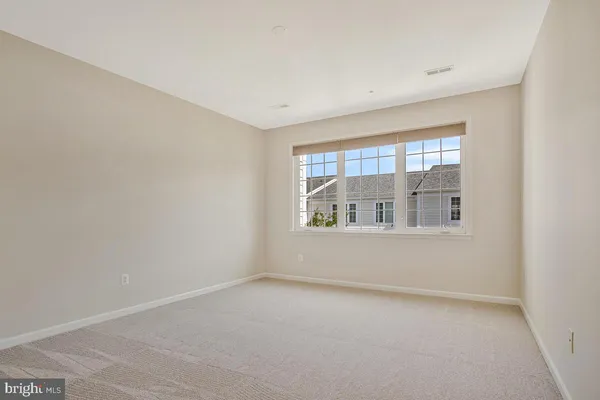 a bedroom with a large bed couch and a large window