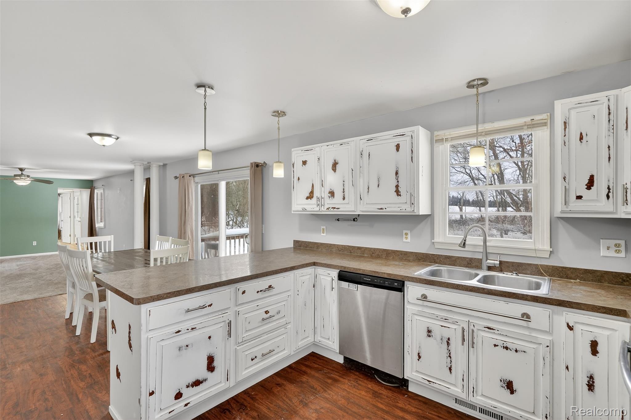 5417 Rensselear Drive Lapeer, MI 48446 - Photo 14 of 41 Kitchen with white cabinets, a peninsula, dishwasher, pendant lighting, and dark countertops