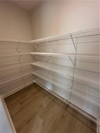 a view of empty room with wooden floor and window