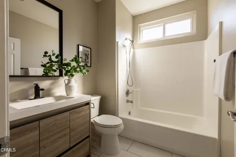 a bathroom with a granite countertop sink toilet a large mirror a shower and a bathtub
