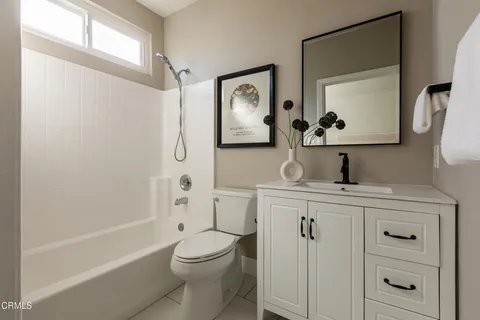 a bathroom with a toilet sink vanity tub and mirror