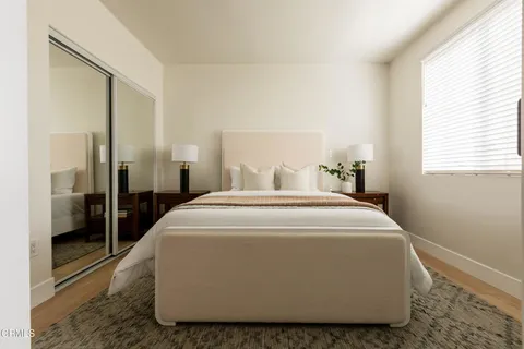 a large white bed sitting in a bedroom next to a window
