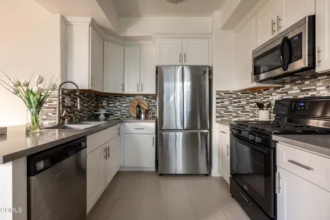 a kitchen with stainless steel appliances a refrigerator microwave stove sink and refrigerator