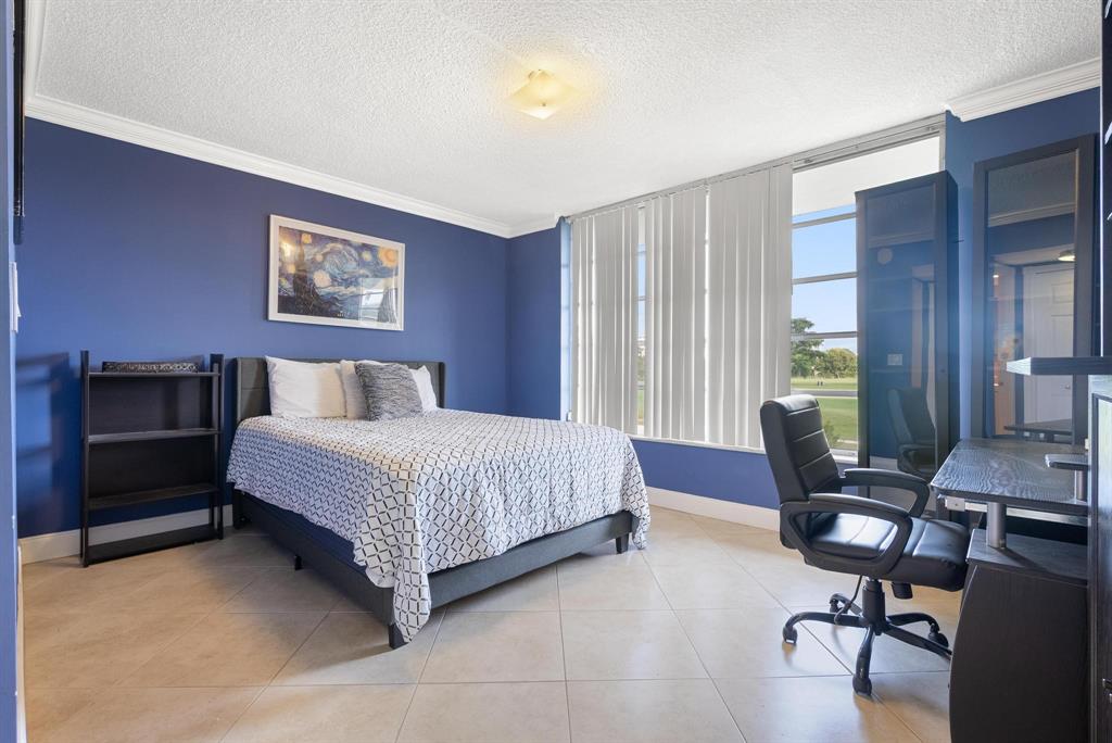 3001 South Palm Aire Drive, Unit 206 Pompano Beach, FL 33069 - Photo 17 of 31 a bedroom with a bed and a desk