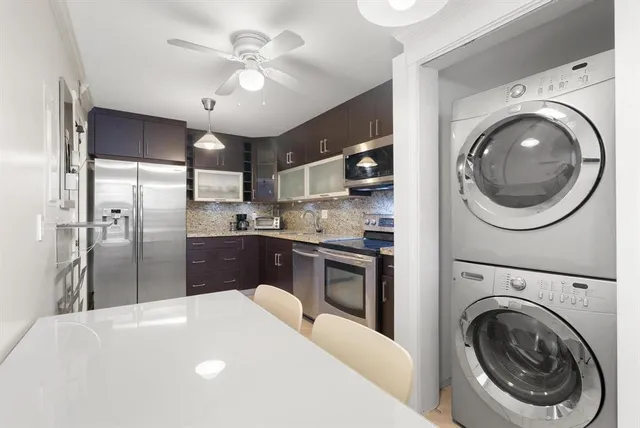 a kitchen with kitchen island a stove a refrigerator and a sink