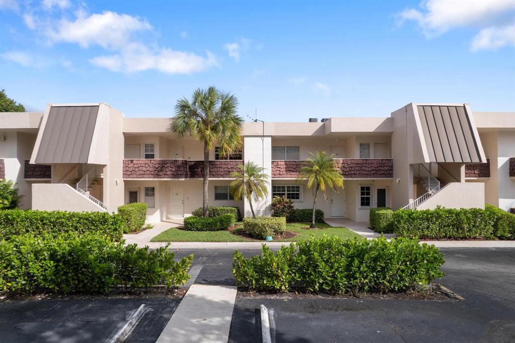 3001 South Palm Aire Drive, Unit 206 Pompano Beach, FL 33069 - Photo 23 of 31 a front view of a residential apartment building with a yard