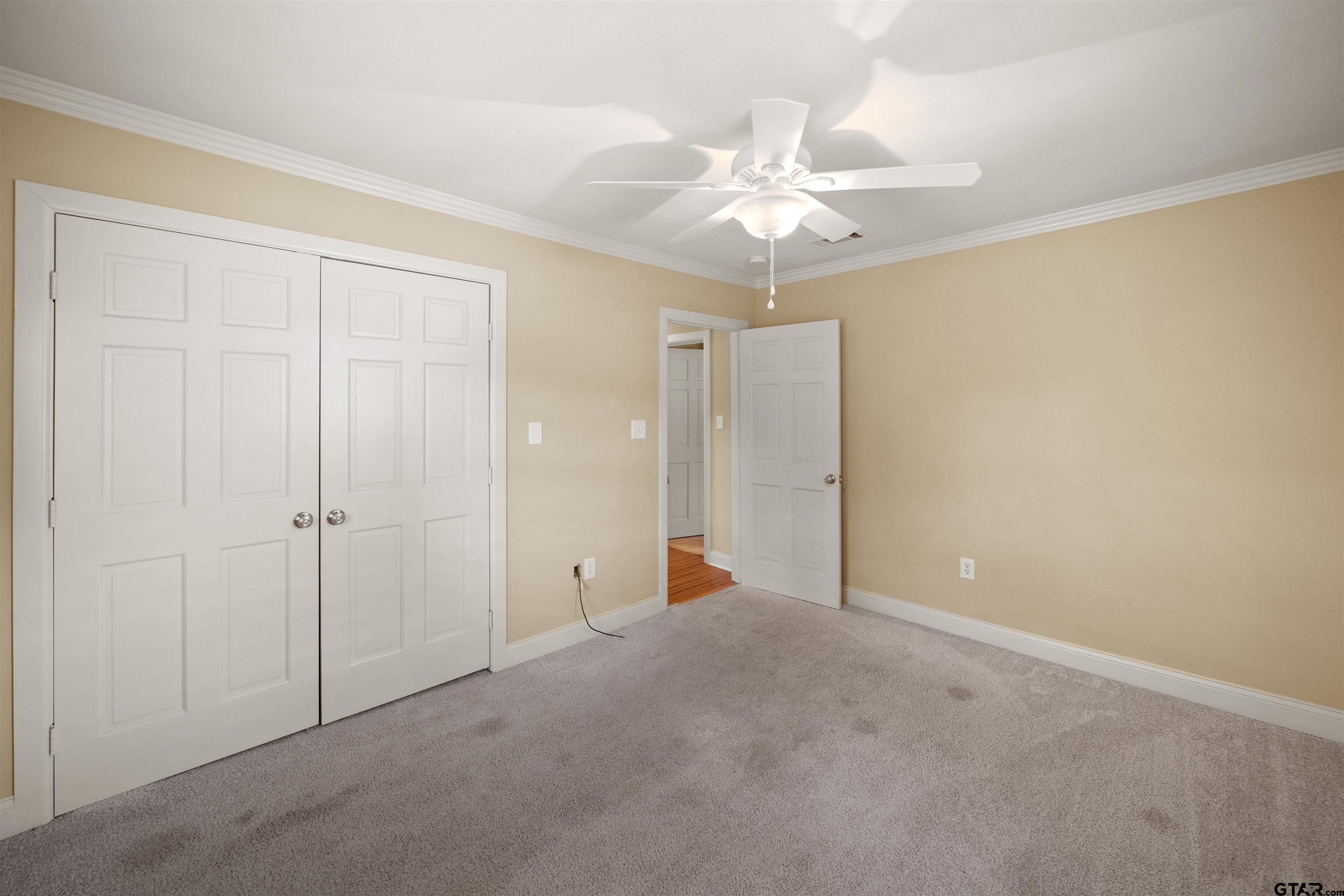 711 South Prairieville Street Athens, TX 75751 - Photo 13 of 27 an empty room with a chandelier fan and closet area