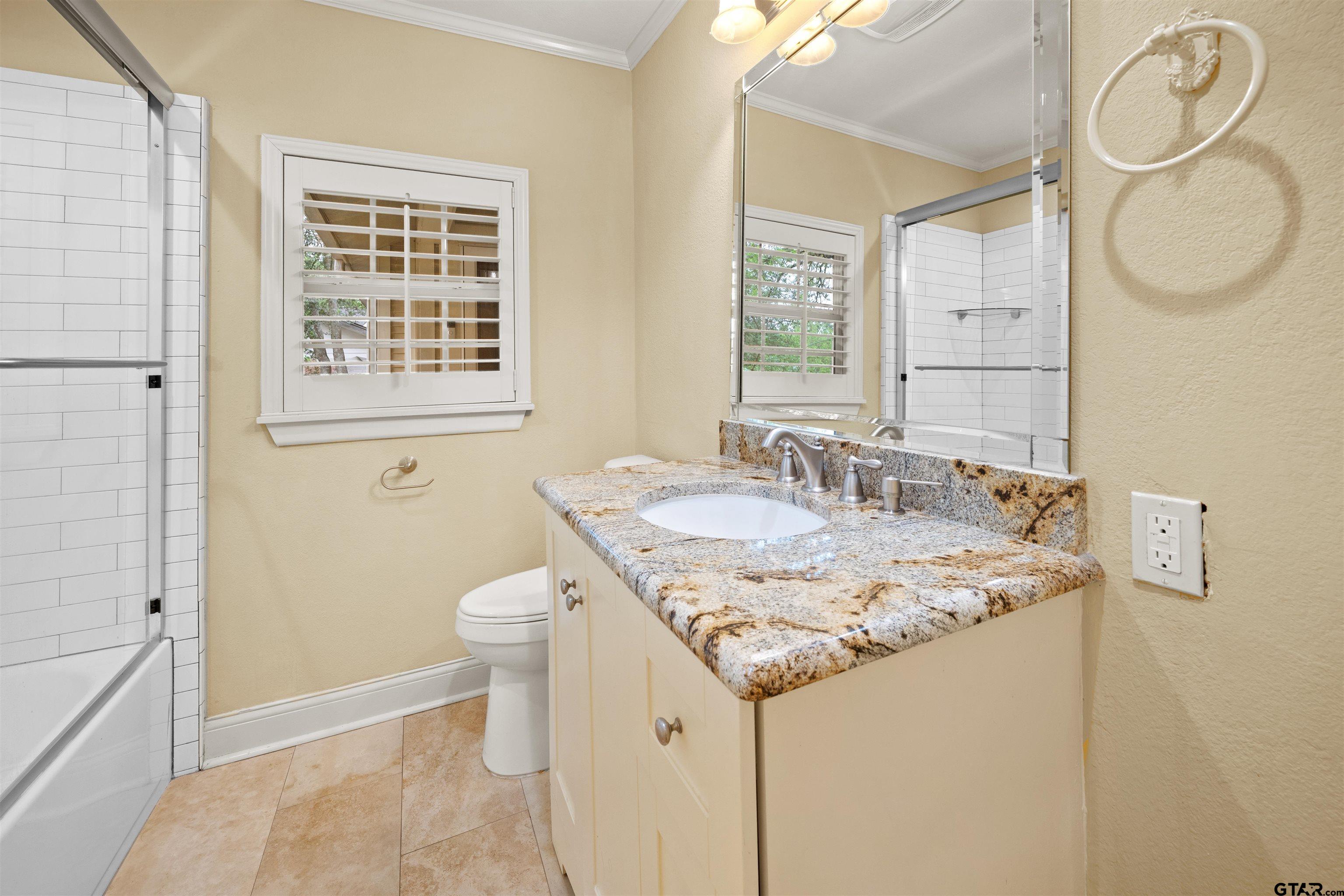 711 South Prairieville Street Athens, TX 75751 - Photo 14 of 27 a bathroom with a granite countertop sink and a mirror