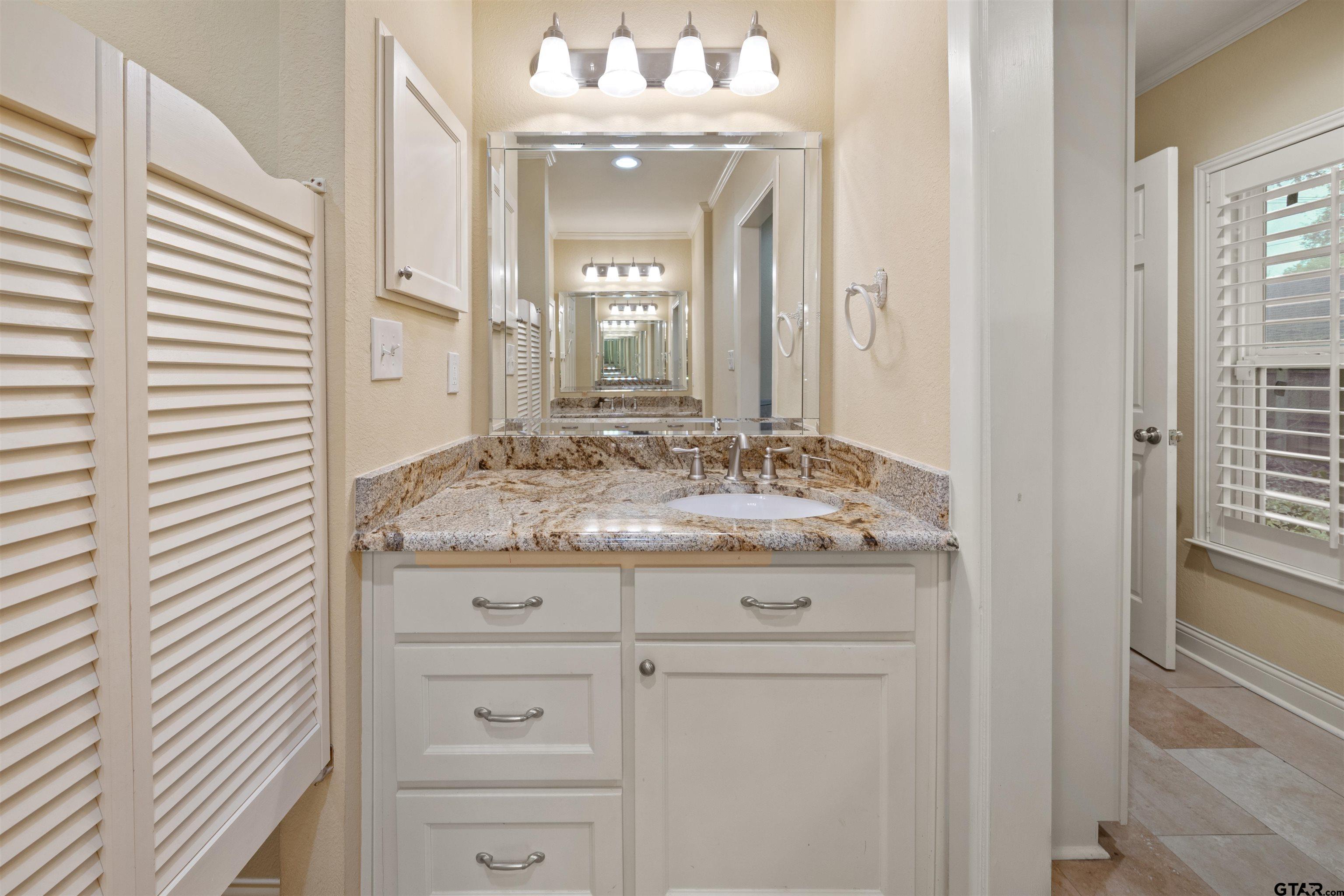 711 South Prairieville Street Athens, TX 75751 - Photo 20 of 27 a bathroom with a granite countertop sink and a mirror