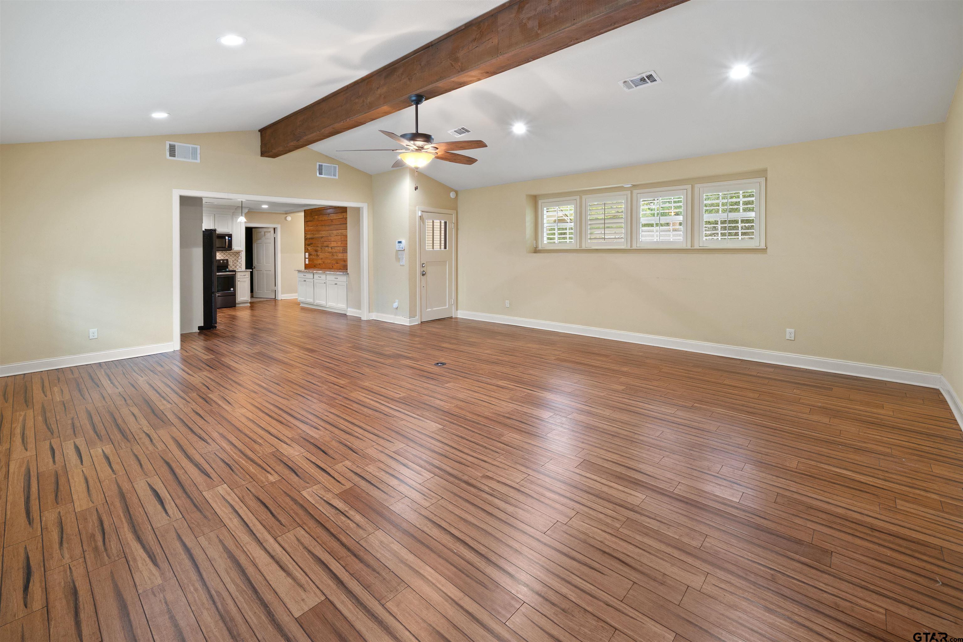 711 South Prairieville Street Athens, TX 75751 - Photo 2 of 27 an empty room with wooden floor and windows