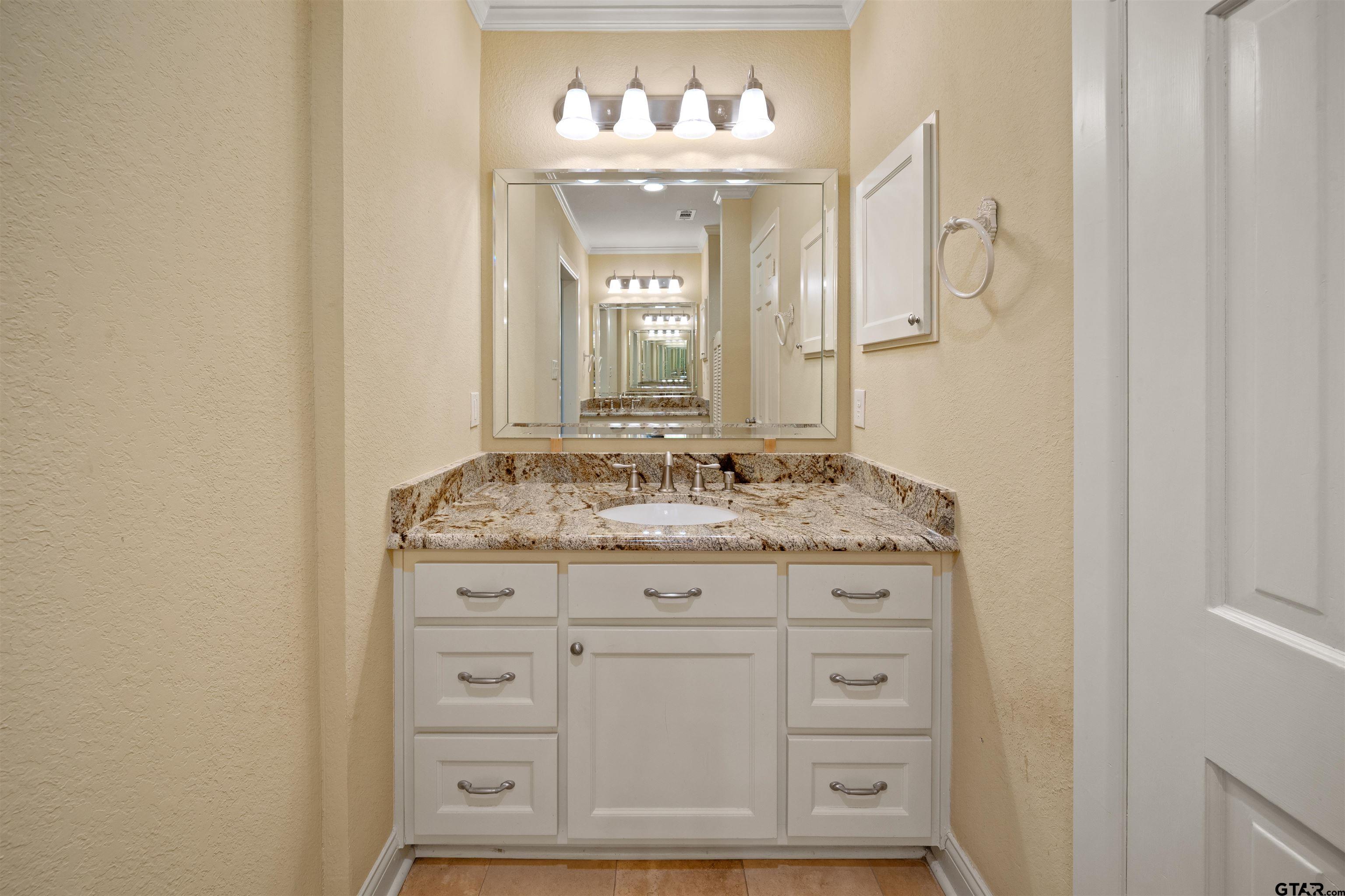 711 South Prairieville Street Athens, TX 75751 - Photo 21 of 27 a bathroom with a granite countertop sink and a mirror