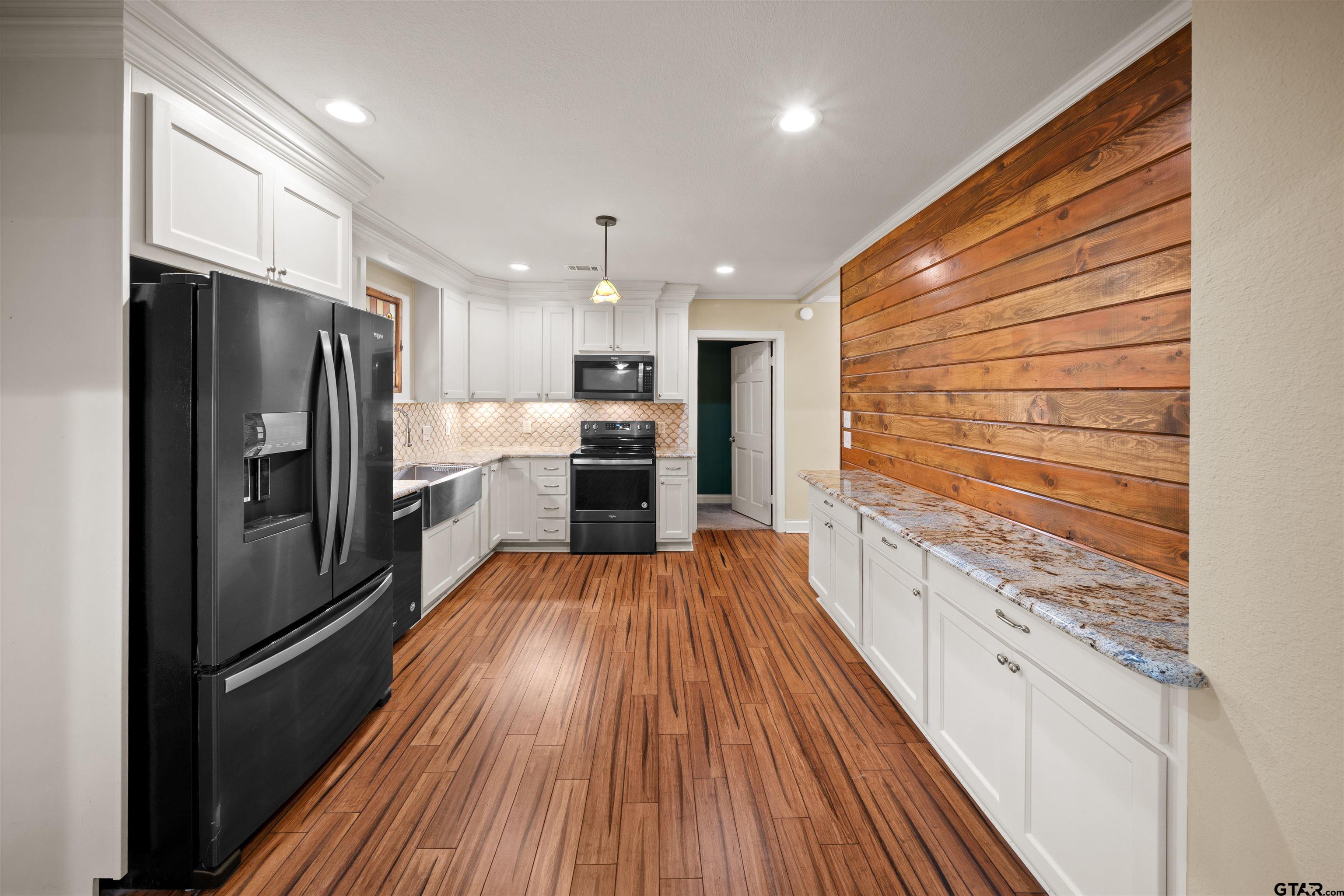 711 South Prairieville Street Athens, TX 75751 - Photo 6 of 27 a kitchen with stainless steel appliances a refrigerator and a stove top oven