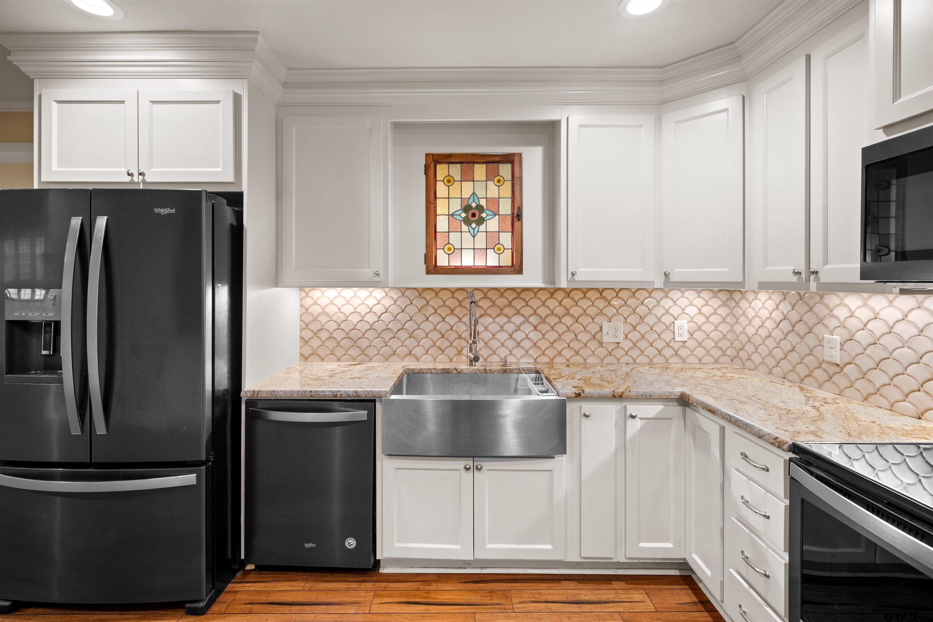 711 South Prairieville Street Athens, TX 75751 - Photo 7 of 27 a kitchen with granite countertop a refrigerator and a sink