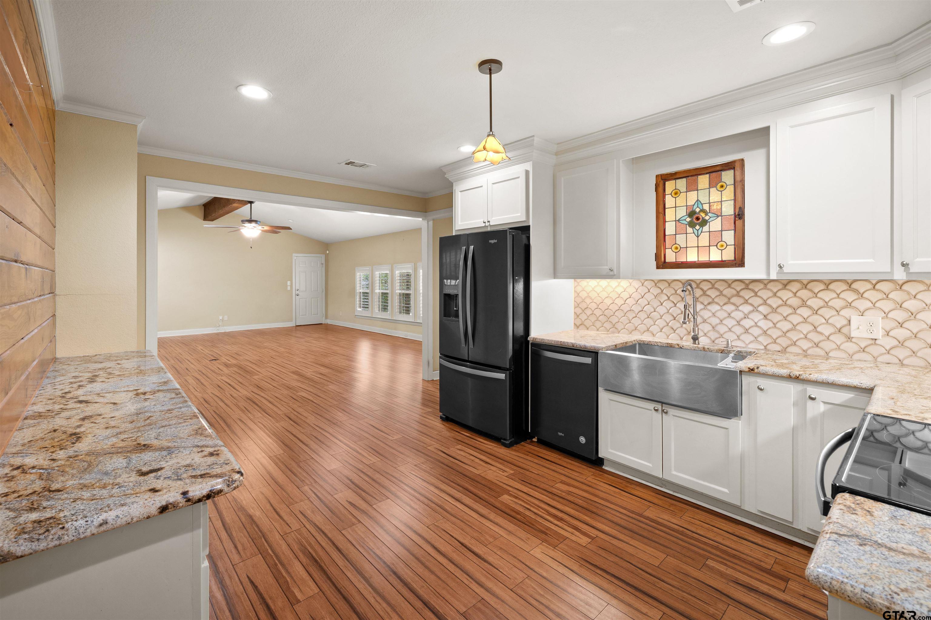 711 South Prairieville Street Athens, TX 75751 - Photo 8 of 27 a kitchen with granite countertop a refrigerator and a sink