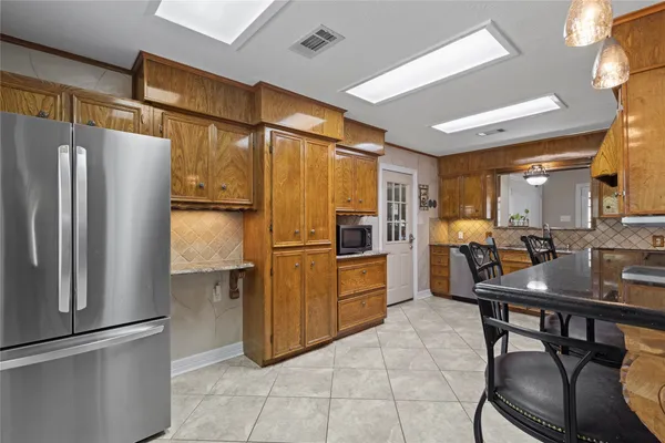 a kitchen with refrigerator and chairs