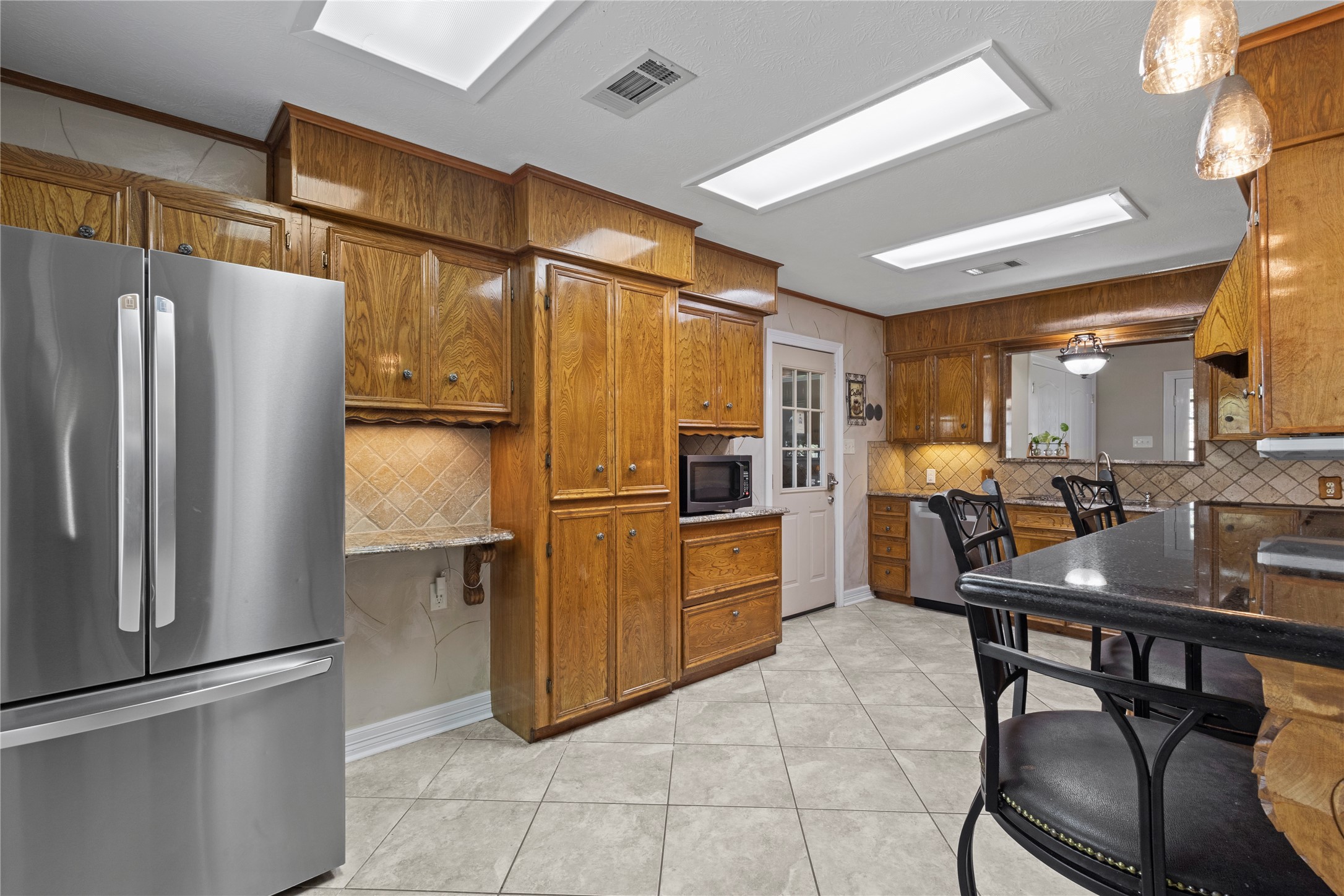 11546 Davidson Road Beaumont, TX 77705 - Photo 18 of 40 a kitchen with refrigerator and chairs