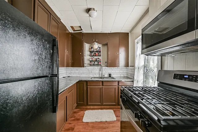 a kitchen with a sink stainless steel appliances a counter space and cabinets
